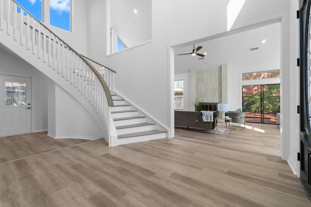 foyer with a healthy amount of sunlight, stairs, and wood finished floors