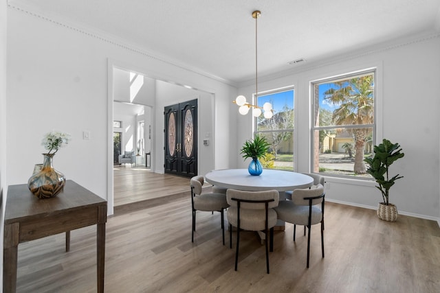 dining area featuring a chandelier, plenty of natural light, light wood-type flooring, and visible vents