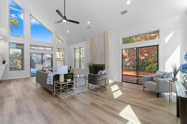 living room with visible vents, high vaulted ceiling, ceiling fan, and wood finished floors