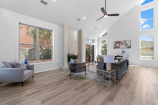 living area featuring visible vents, high vaulted ceiling, ceiling fan, and wood finished floors