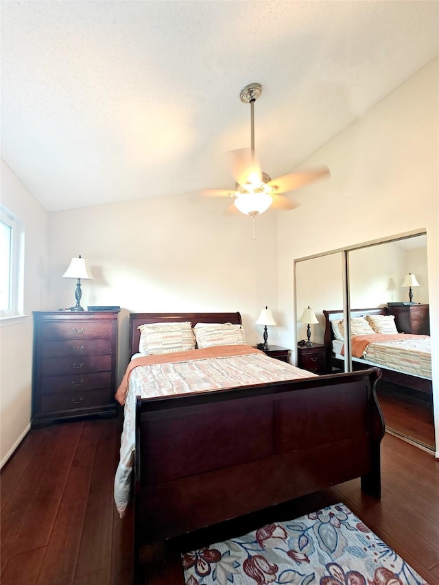 bedroom featuring ceiling fan, vaulted ceiling, a closet, and dark wood finished floors