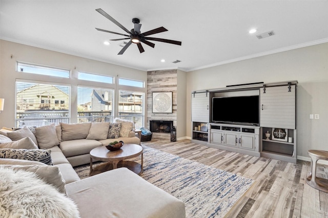 living room with baseboards, light wood finished floors, visible vents, and crown molding