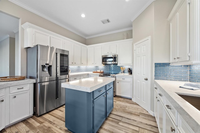 kitchen featuring stainless steel appliances, light countertops, white cabinets, and blue cabinets