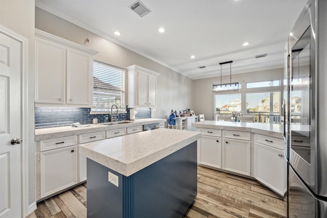 kitchen with light wood finished floors, light countertops, visible vents, appliances with stainless steel finishes, and white cabinetry