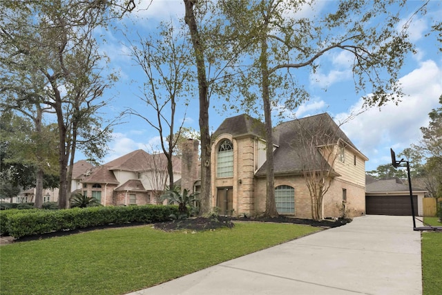 view of front of property with a front lawn, brick siding, and an outdoor structure