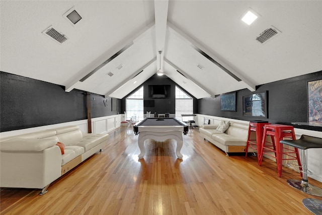 game room featuring visible vents, lofted ceiling with beams, a wainscoted wall, and hardwood / wood-style floors