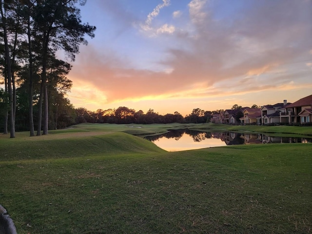 view of home's community with a yard and a water view