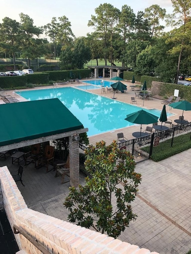 community pool featuring a patio and fence