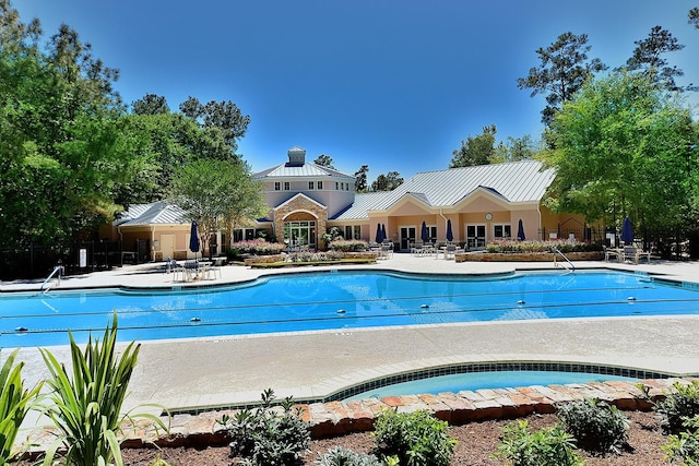 pool featuring a patio area, fence, and a community hot tub