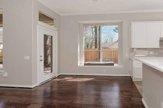 interior space featuring crown molding, baseboards, and wood finished floors