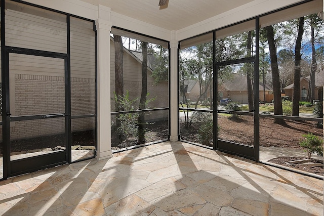 unfurnished sunroom with a ceiling fan