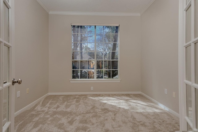 spare room featuring ornamental molding, carpet flooring, and baseboards