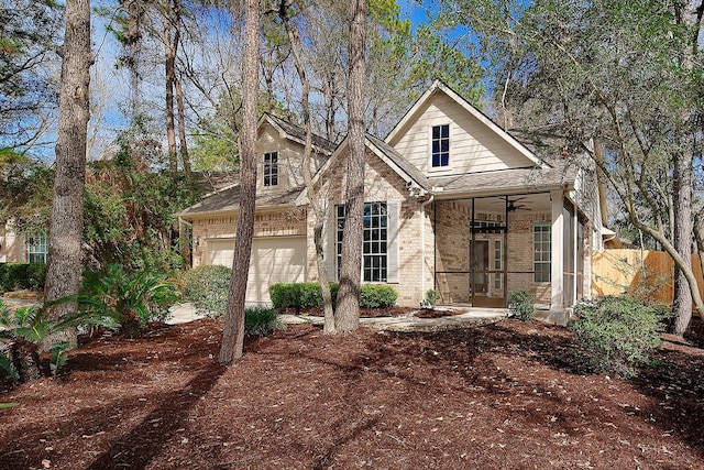 view of front of property with a sunroom, a shingled roof, a ceiling fan, and brick siding