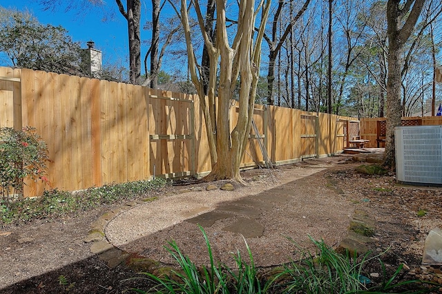 view of yard with a fenced backyard and central air condition unit