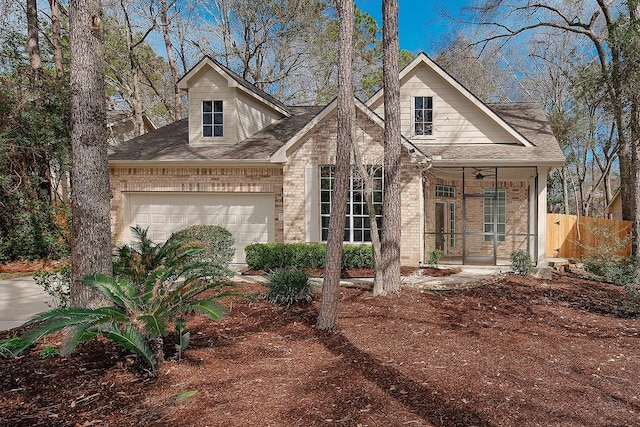 view of front of house with a garage, roof with shingles, fence, and brick siding