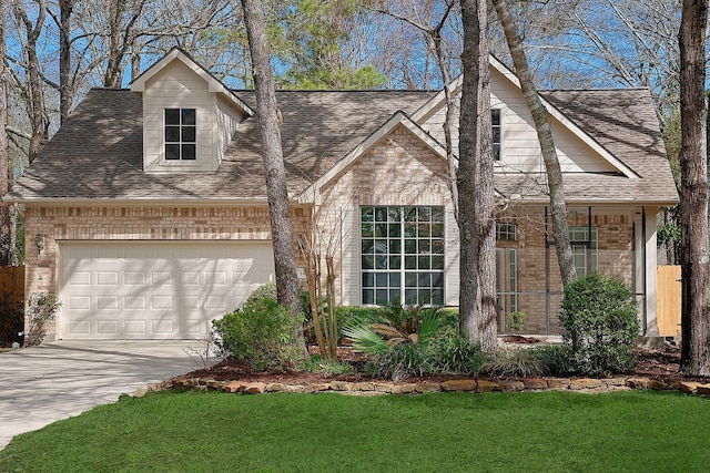 view of front of property featuring an attached garage, a shingled roof, and brick siding