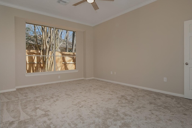 spare room with baseboards, carpet floors, visible vents, and crown molding