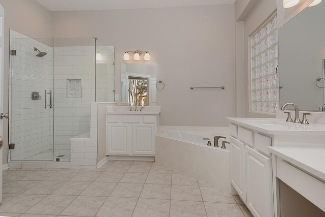 full bath featuring a stall shower, tile patterned flooring, a garden tub, and a sink