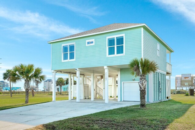 23107 Buena St, Galveston, TX 77554 - coastal home featuring a carport, concrete driveway, a front lawn, and stairs