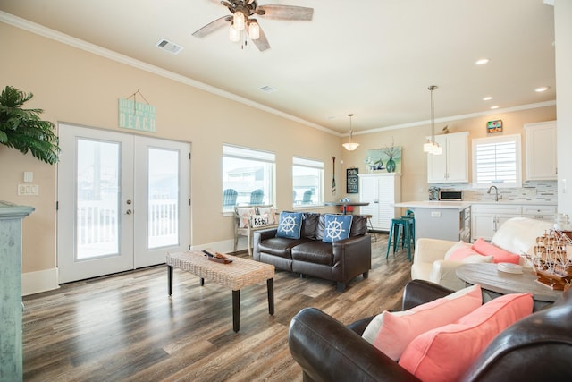 living room featuring visible vents, ornamental molding, wood finished floors, and french doors