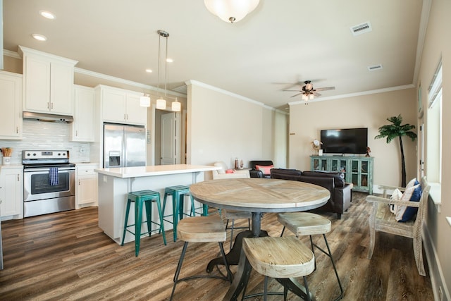 kitchen featuring under cabinet range hood, visible vents, appliances with stainless steel finishes, backsplash, and dark wood finished floors