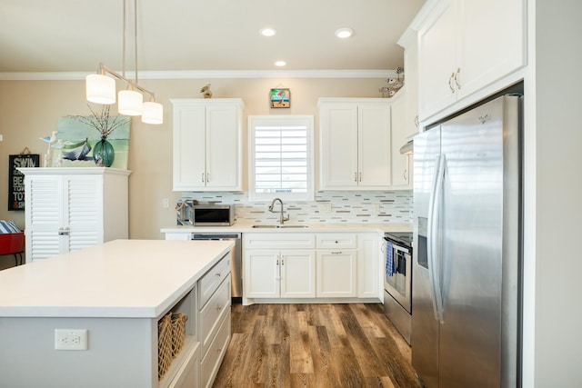 kitchen with appliances with stainless steel finishes, tasteful backsplash, a sink, and ornamental molding