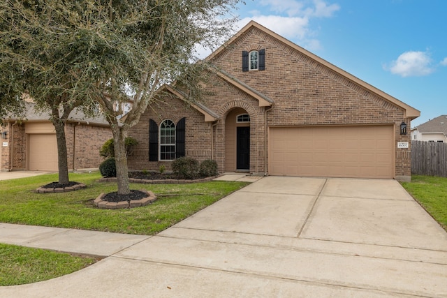 view of front facade featuring a front lawn, brick siding, and an attached garage