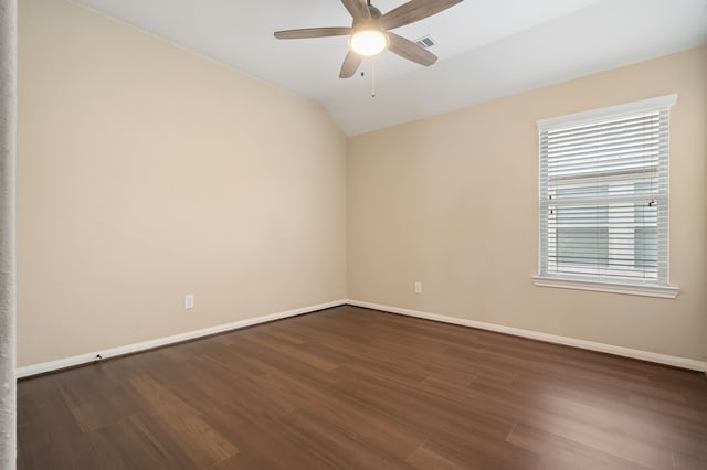 empty room with baseboards, visible vents, a ceiling fan, lofted ceiling, and dark wood-style flooring