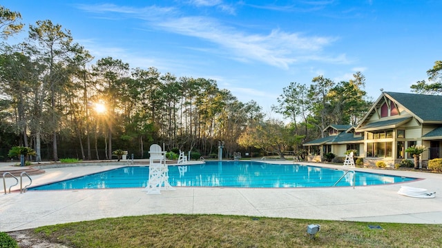 pool with a patio area and fence