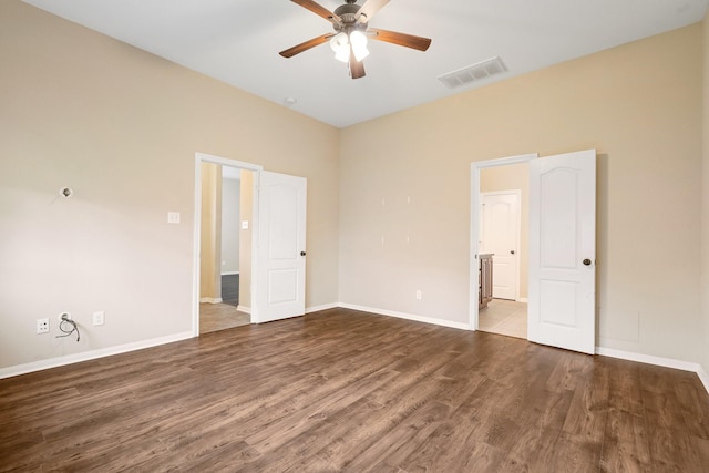 spare room featuring baseboards, ceiling fan, visible vents, and wood finished floors