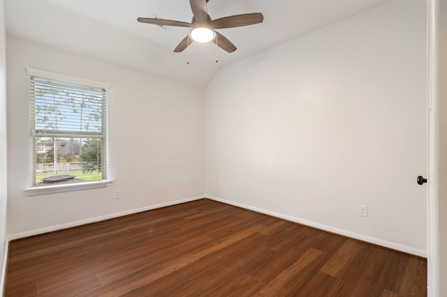 empty room featuring a ceiling fan, baseboards, vaulted ceiling, and dark wood-type flooring