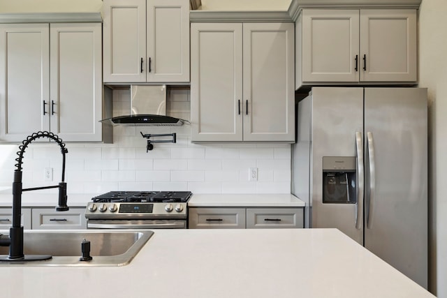 kitchen featuring stainless steel appliances, light countertops, and wall chimney exhaust hood