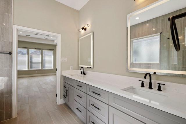 bathroom featuring baseboards, double vanity, a sink, and wood tiled floor