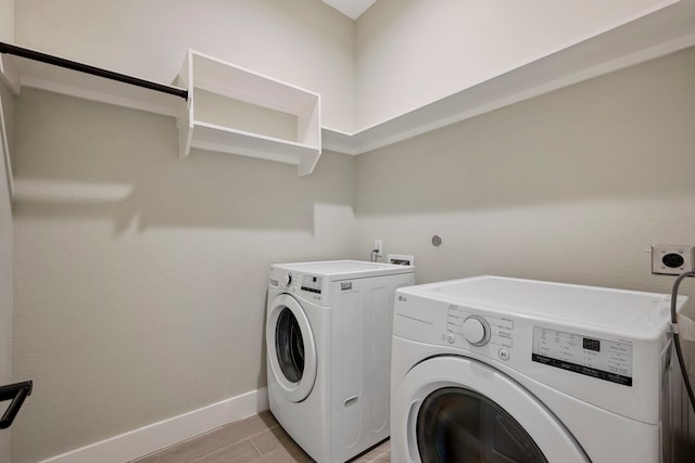 laundry room featuring laundry area, light wood finished floors, washing machine and dryer, and baseboards