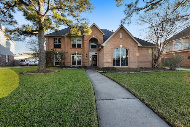 traditional-style home with a front yard and brick siding