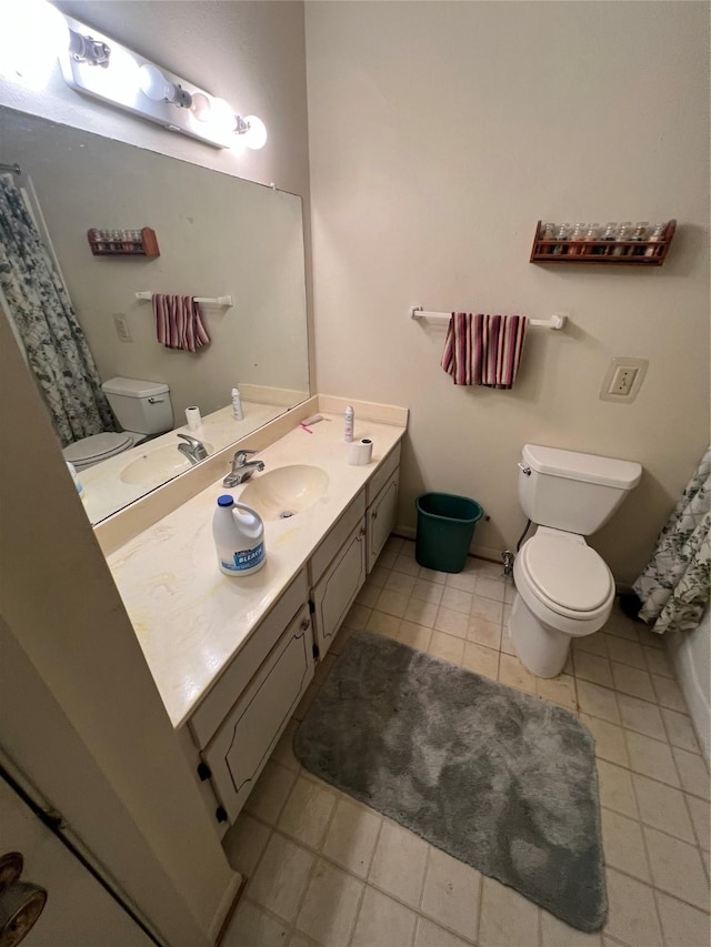 bathroom featuring toilet, baseboards, and vanity