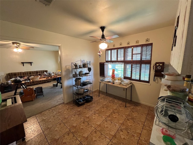 interior space featuring visible vents, a ceiling fan, and baseboards