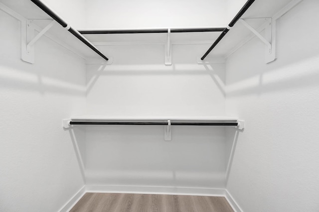 walk in closet with wood finished floors