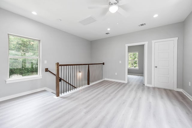 empty room featuring light wood finished floors, baseboards, visible vents, and recessed lighting