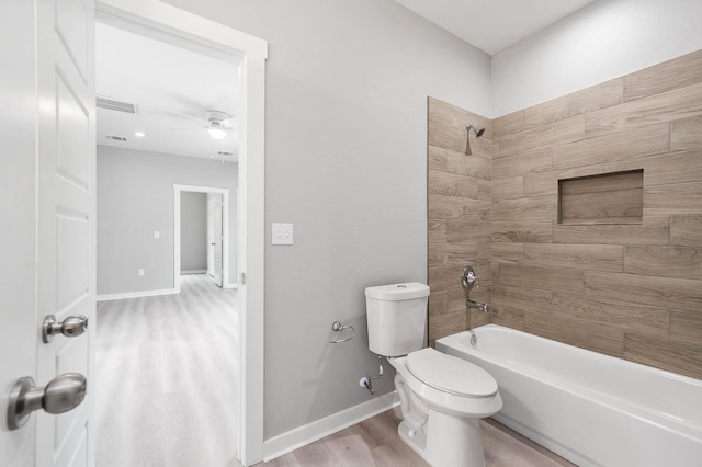 full bath with shower / tub combination, toilet, wood finished floors, visible vents, and baseboards