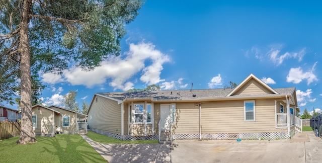 rear view of house featuring a yard and fence