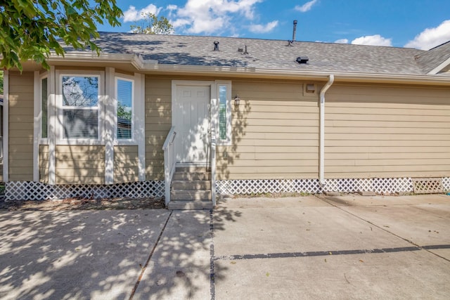 exterior space featuring roof with shingles