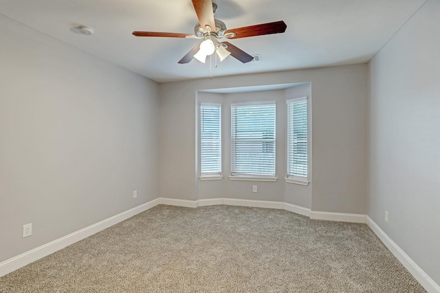 unfurnished room with carpet flooring, ceiling fan, and baseboards