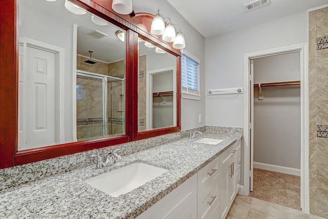 bathroom with a shower stall, visible vents, and a sink