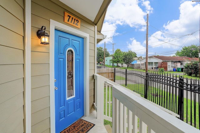 entrance to property with a porch, a residential view, and fence