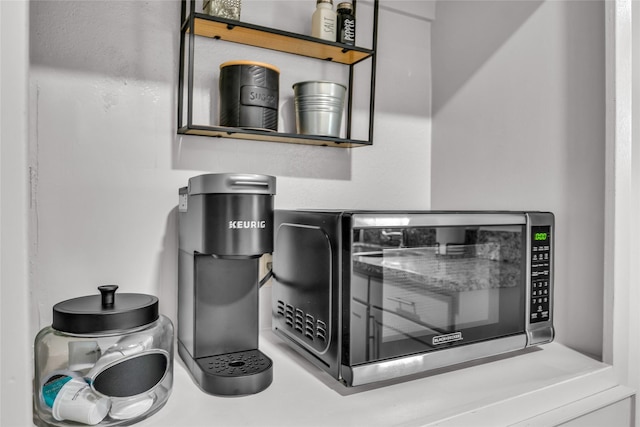 room details featuring open shelves and stainless steel microwave