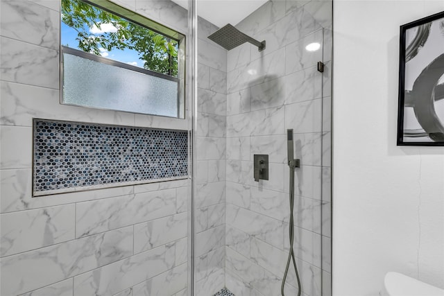 bathroom with tiled shower and toilet