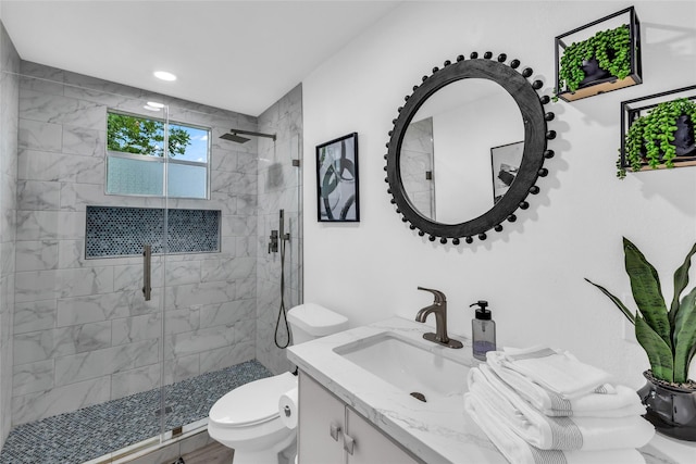 bathroom with a stall shower, vanity, and toilet