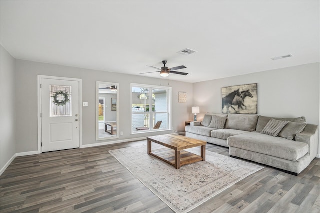 living room with a ceiling fan, wood finished floors, visible vents, and baseboards