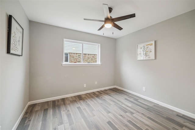 unfurnished room featuring wood finished floors, a ceiling fan, and baseboards